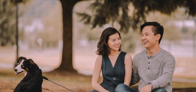 Happy couple sitting in a park with their dog